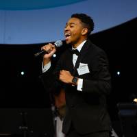 Student performer singing on stage